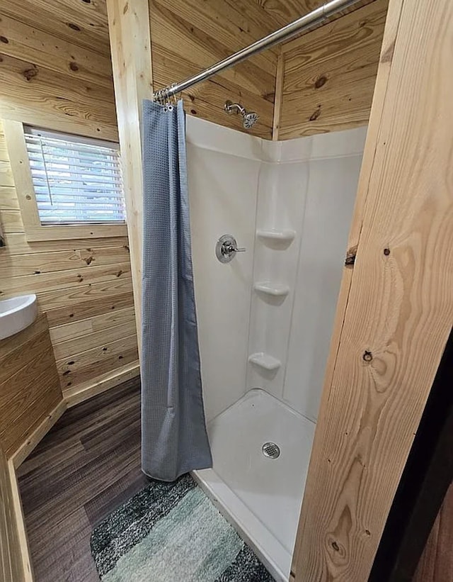 bathroom featuring curtained shower and wood walls