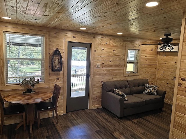 living room with ceiling fan, dark hardwood / wood-style floors, wooden ceiling, and wooden walls