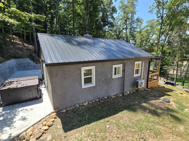 view of side of property featuring a hot tub and ac unit