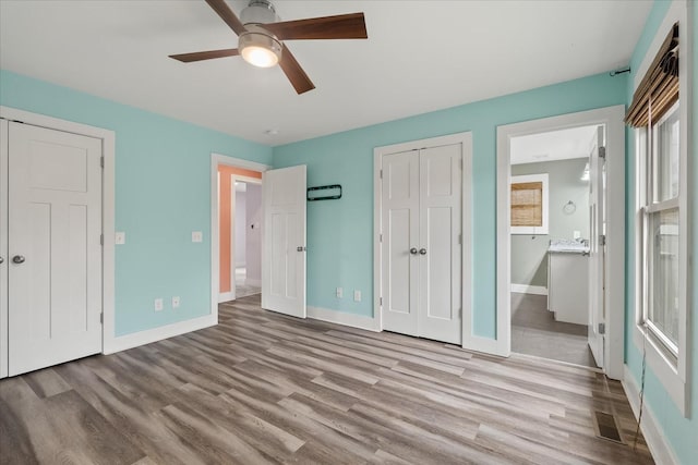 unfurnished bedroom featuring connected bathroom, a closet, ceiling fan, and light wood-type flooring