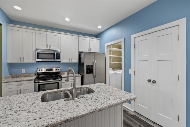 kitchen featuring sink, white cabinetry, stainless steel appliances, washing machine and clothes dryer, and dark hardwood / wood-style flooring