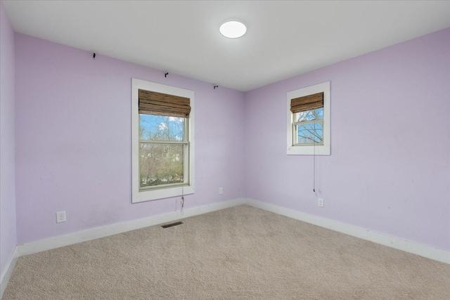 carpeted empty room featuring a wealth of natural light