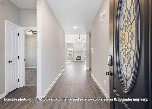 interior space with ceiling fan, a fireplace, and dark hardwood / wood-style floors