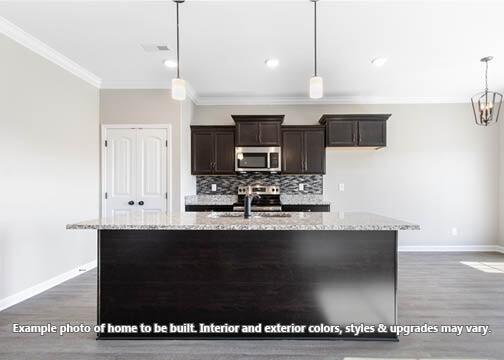 kitchen featuring sink, pendant lighting, backsplash, and light stone counters