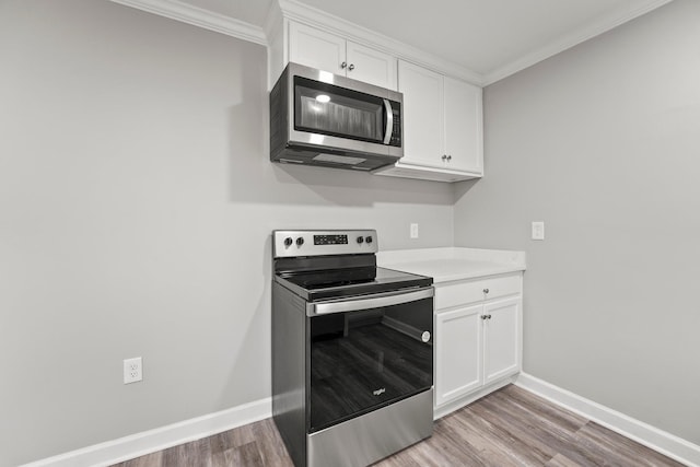 kitchen with white cabinets, light wood-type flooring, stainless steel appliances, and light countertops