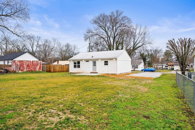 back of house featuring fence and a lawn