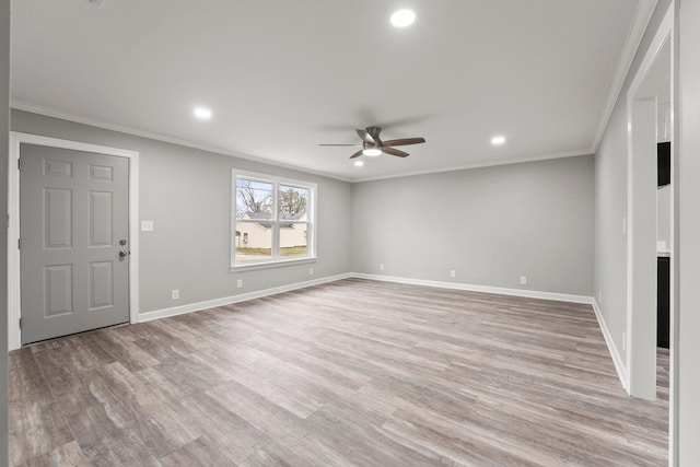 unfurnished living room featuring crown molding, light wood-style flooring, and baseboards