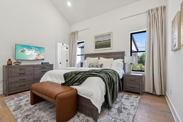 bedroom featuring light hardwood / wood-style flooring and high vaulted ceiling