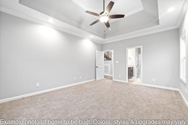 unfurnished bedroom featuring crown molding, a tray ceiling, light colored carpet, and ensuite bathroom