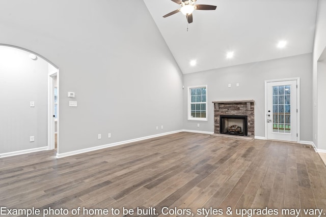 unfurnished living room featuring wood-type flooring, a healthy amount of sunlight, and high vaulted ceiling