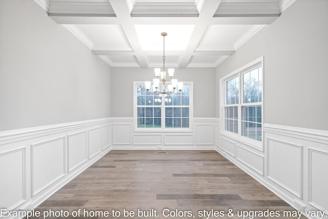 unfurnished dining area with coffered ceiling, a notable chandelier, beam ceiling, and light hardwood / wood-style floors