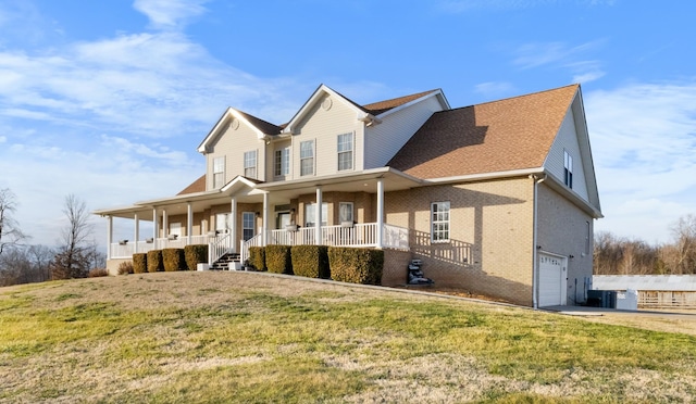 view of front of house with a garage, a front yard, and covered porch