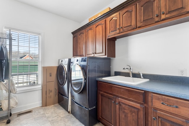 laundry area featuring cabinets, sink, and washing machine and clothes dryer