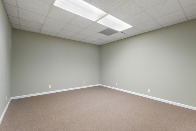 spare room featuring a drop ceiling and carpet