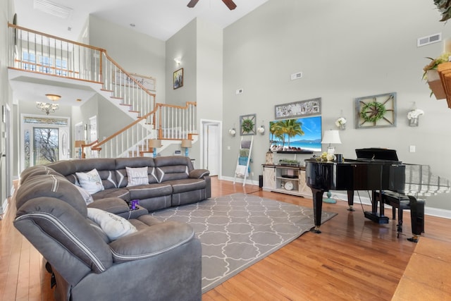 living room featuring ceiling fan with notable chandelier and hardwood / wood-style floors