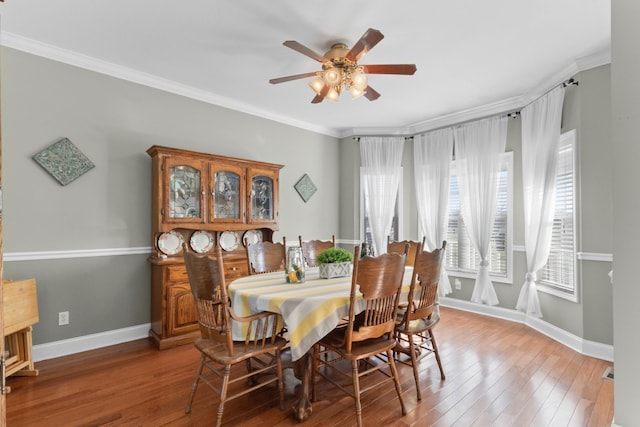 dining space with crown molding, ceiling fan, and hardwood / wood-style flooring