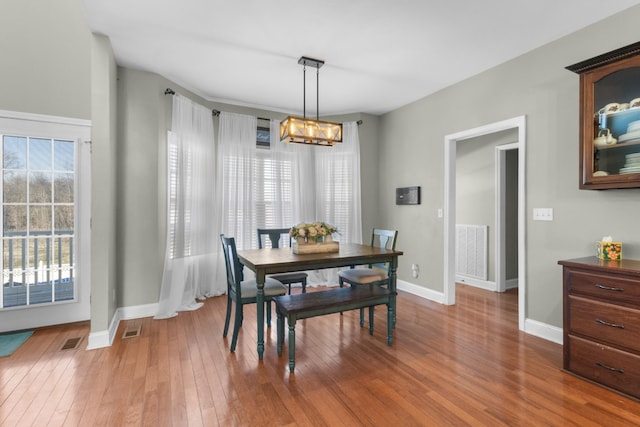 dining space featuring hardwood / wood-style floors and an inviting chandelier