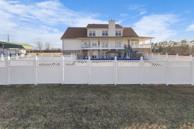 rear view of property featuring a carport and a lawn