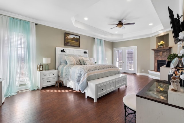 bedroom with crown molding, dark hardwood / wood-style floors, a raised ceiling, and access to exterior