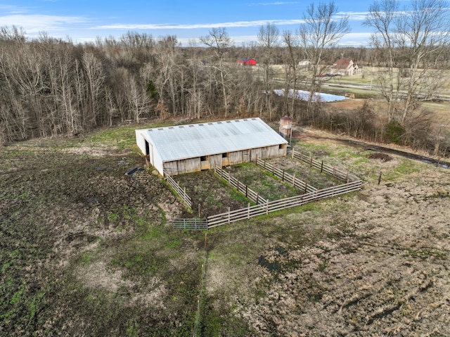 birds eye view of property featuring an outbuilding, a water view, and a rural view