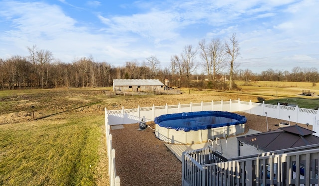 view of pool with a rural view and a yard