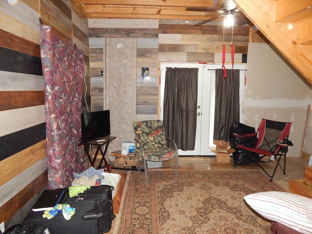 living room featuring ceiling fan and wooden walls