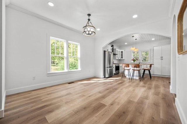 dining space featuring ornamental molding, a chandelier, and light hardwood / wood-style floors