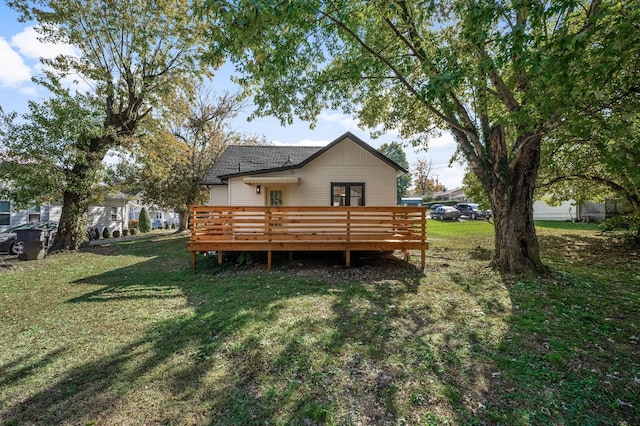 rear view of house with a lawn and a deck