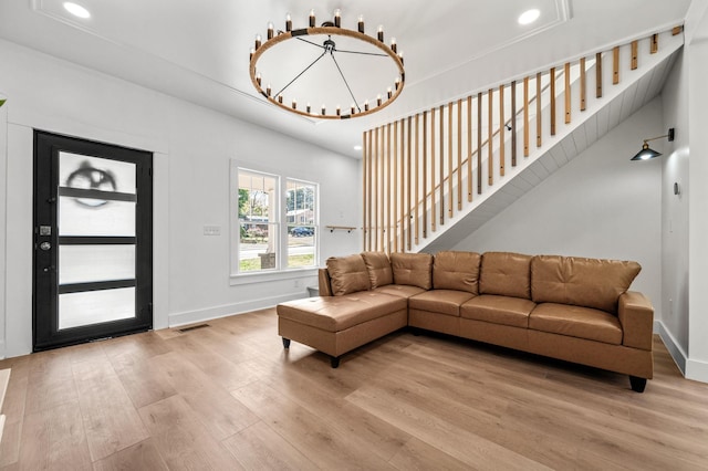 living room featuring a notable chandelier and light wood-type flooring