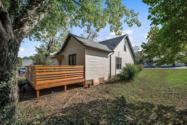 view of property exterior with a wooden deck and a lawn