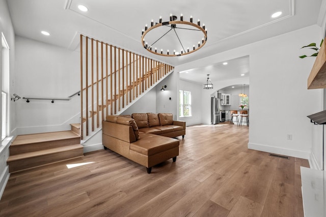 living room featuring wood-type flooring and a notable chandelier