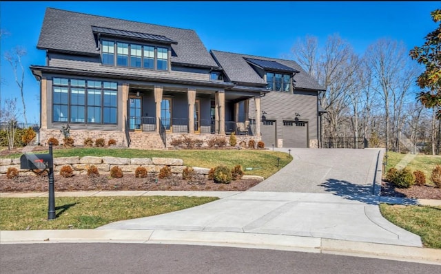 view of front of house featuring a porch, a garage, and a front lawn