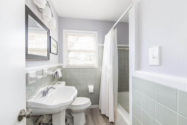 full bathroom featuring hardwood / wood-style floors, sink, tile walls, toilet, and shower / bath combo