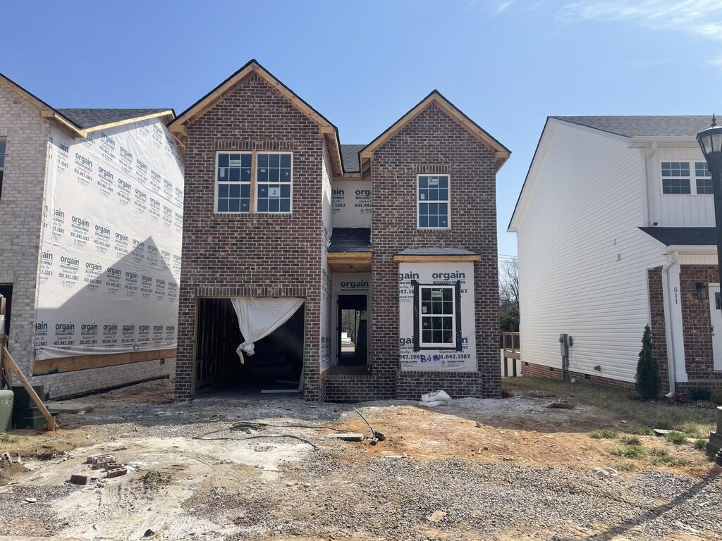 view of front of property with an attached garage and brick siding