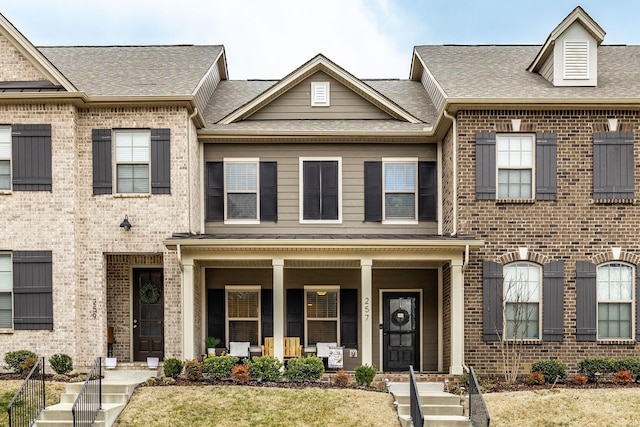 multi unit property with a front yard and a porch