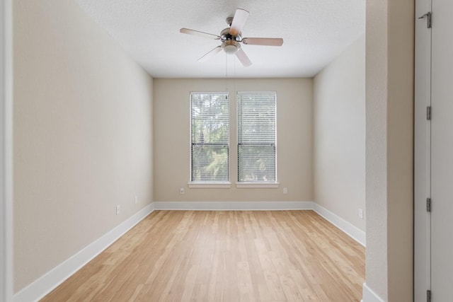 empty room with ceiling fan, light hardwood / wood-style floors, and a textured ceiling