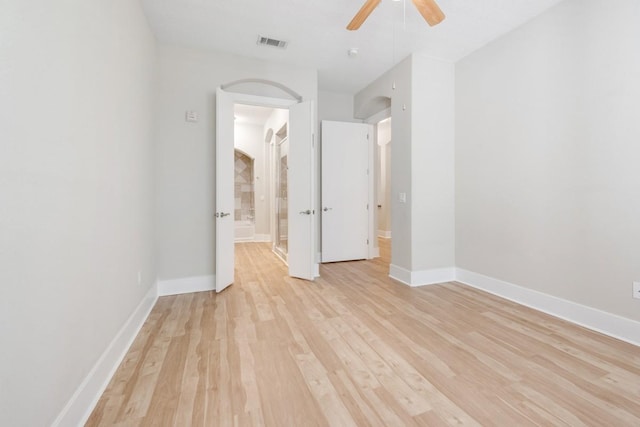 unfurnished bedroom featuring ceiling fan, ensuite bathroom, and light hardwood / wood-style flooring