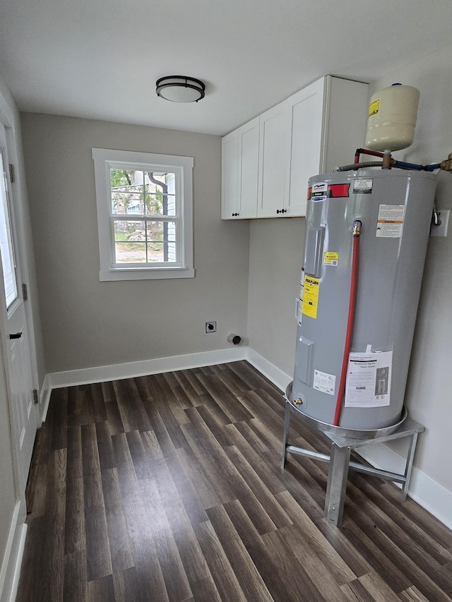 clothes washing area with electric dryer hookup, cabinets, dark hardwood / wood-style floors, and electric water heater