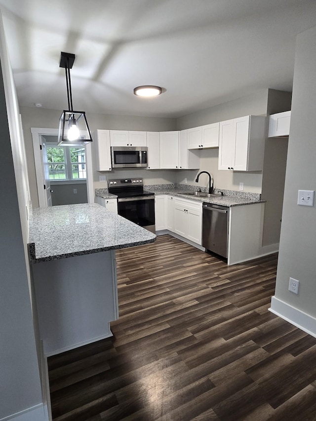 kitchen featuring white cabinetry, sink, hanging light fixtures, stainless steel appliances, and light stone countertops