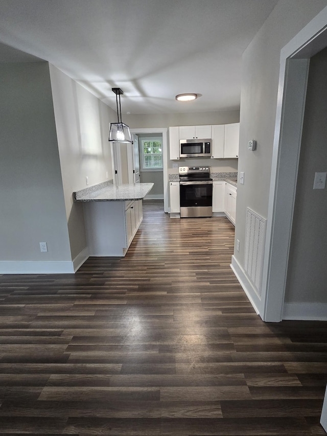 kitchen with appliances with stainless steel finishes, decorative light fixtures, white cabinetry, dark hardwood / wood-style flooring, and light stone counters