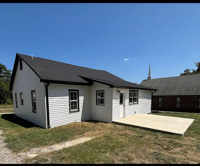 back of house with a lawn and a patio