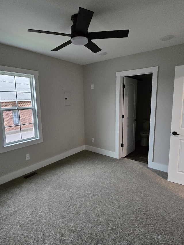 unfurnished bedroom with ceiling fan, light colored carpet, and ensuite bath