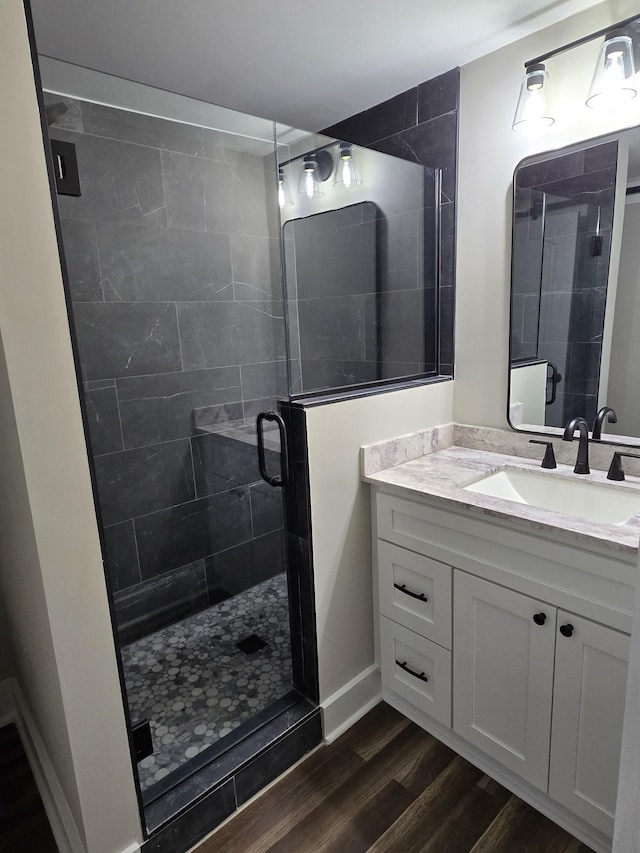 bathroom with an enclosed shower, vanity, and hardwood / wood-style flooring