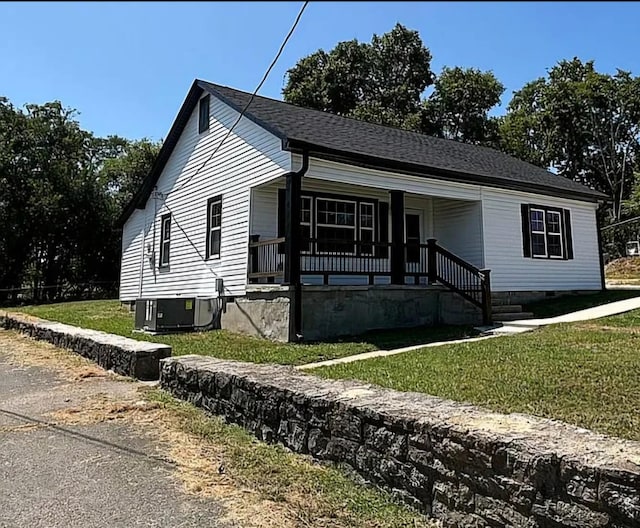 view of front of house featuring a porch, a front yard, and central AC unit