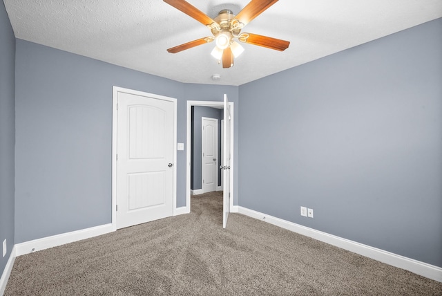 unfurnished bedroom featuring ceiling fan, carpet, and a textured ceiling