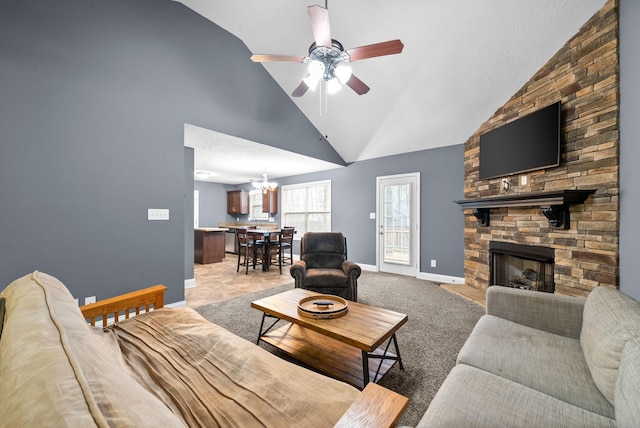 living room with ceiling fan with notable chandelier, carpet, high vaulted ceiling, and a fireplace