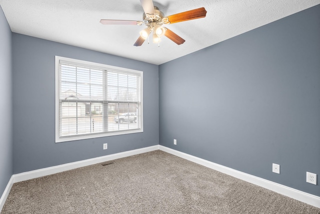 empty room with a textured ceiling, ceiling fan, and carpet