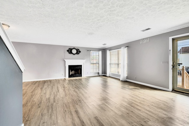 unfurnished living room featuring crown molding, a textured ceiling, and light hardwood / wood-style floors