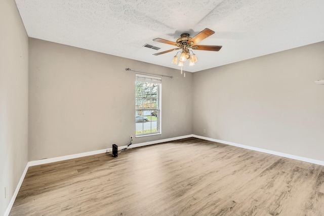 empty room with hardwood / wood-style flooring, ceiling fan, and a textured ceiling