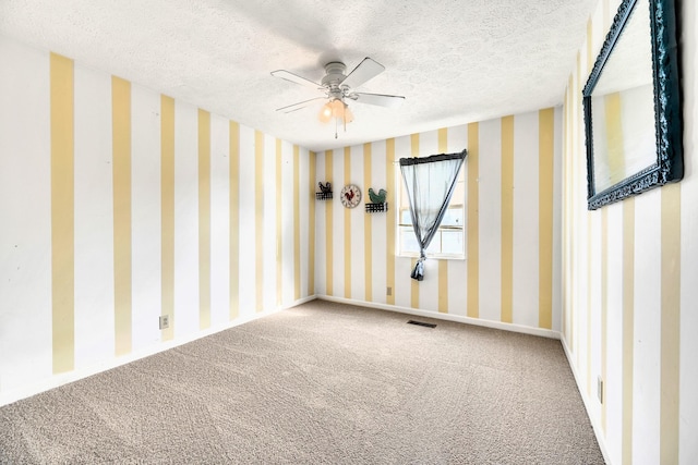 carpeted empty room featuring ceiling fan and a textured ceiling